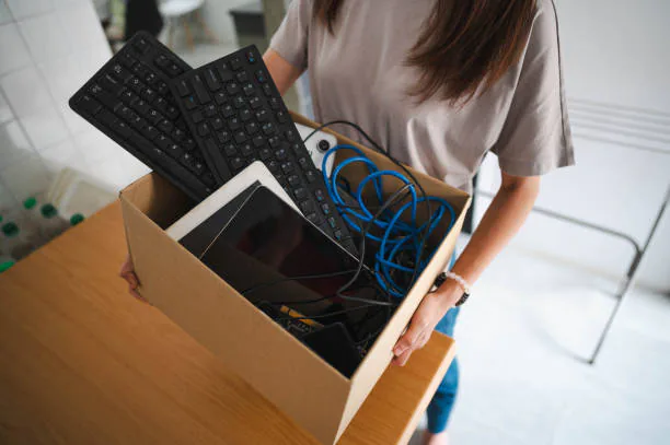 A resident carrying a box of old electronics to be recycled