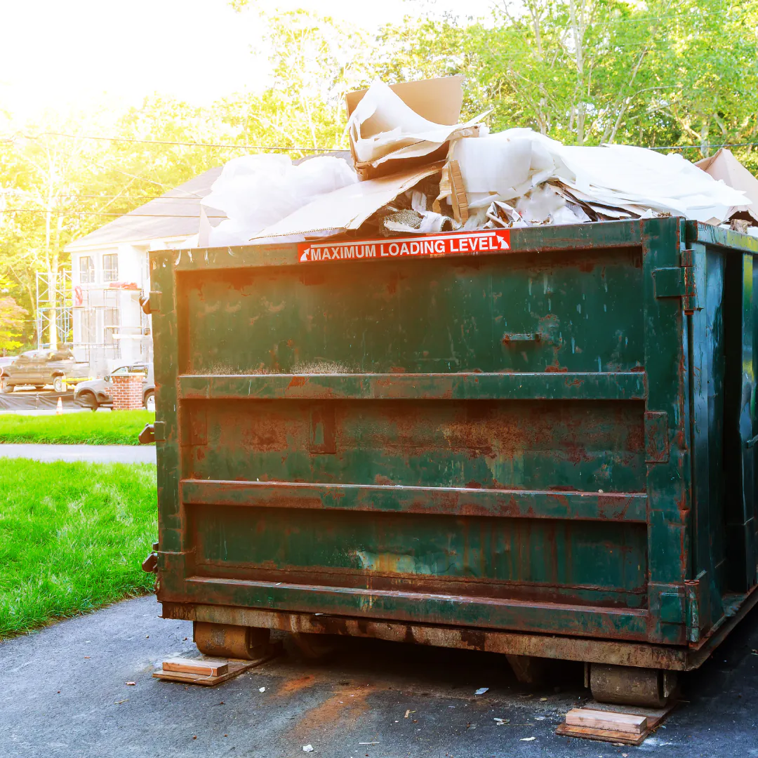 A dumpster on a Canterbury Village street, filled with items dropped off by residents