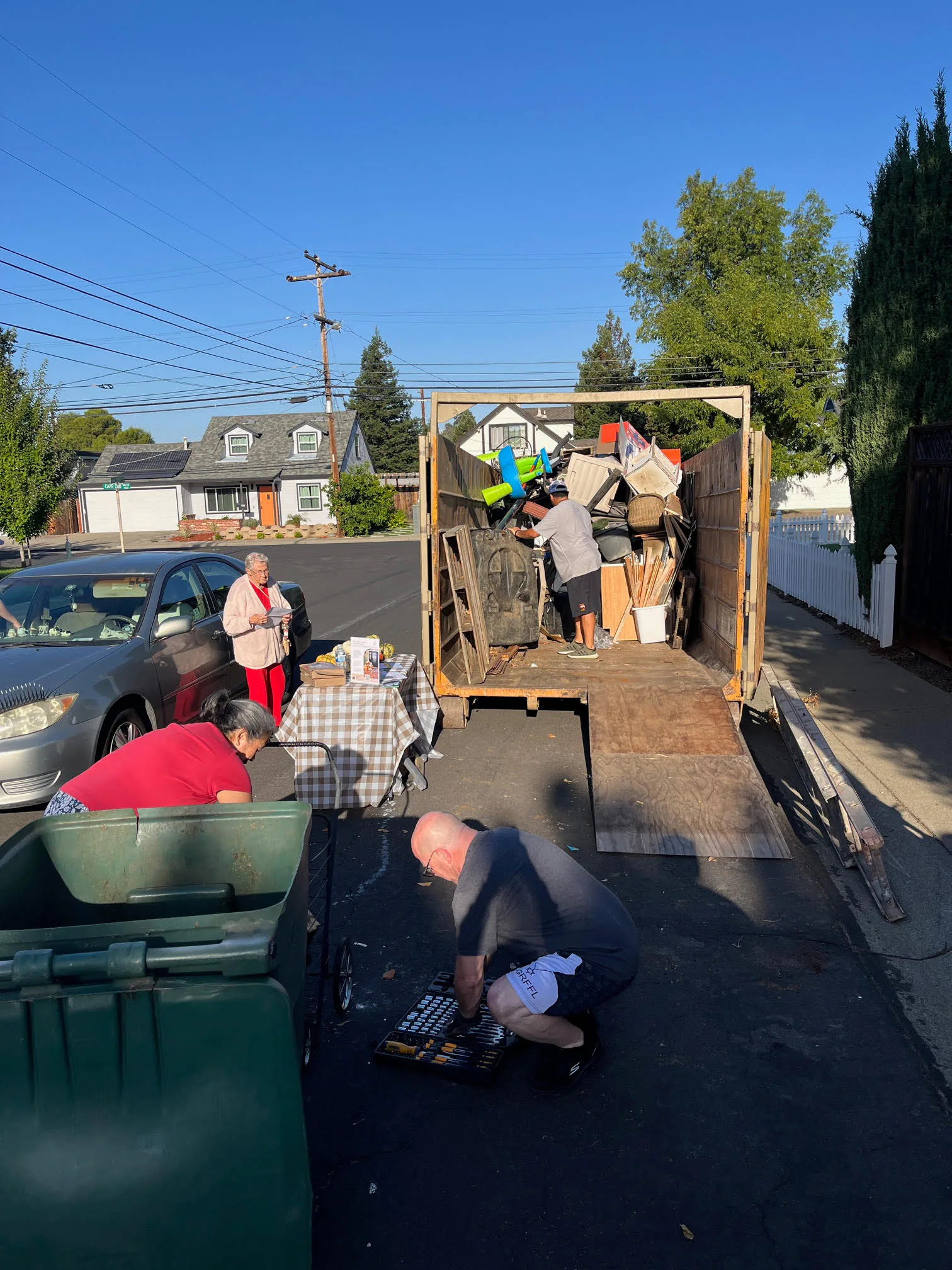 Neighbors working together to move items to the dumpster