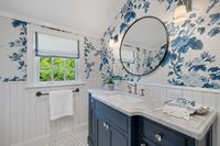 032 - 110 - 6 Snowberry Lane - Bathroom sink with blue themed wall paper and cabinets