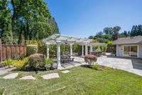 020 - 19 Warwick Court - Backyard dining area with a white pergola, picnic table, outdoor bar, and trees surrounding the  patio.