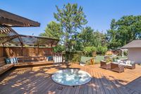 022.5 - 19 Warwick Court - Wooden deck with built-in bench seating, a round hot tub, and an outdoor lounge area