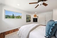 023 - 3190 Bavarian Lane - Bedroom with fireplace and glass window showing the outside trees