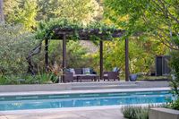 41 - 143 - 25 Haciendas Road - Covered seating area with cushioned patio furniture under a leafy pergola