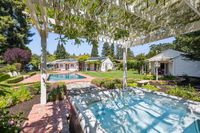 22 - 31 Old Millstone Lane - Backyard view and a hot tub under a pergola, a  swimming pool, and garden.