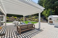 002 - 3165 Lucas Drive - Outdoor patio with white pergola, dining area, and built-in oven.