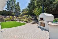 011 - 3165 Lucas Drive - Backyard area with built-in outdoor oven, paver patio, and terraced landscaping.