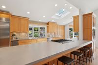 14.5 - 3165 Lucas Drive - Kitchen with wood cabinets and a large island featuring a built-in cooktop.