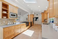 015 - 3165 Lucas Drive - Kitchen with wood cabinets and a large island featuring a built-in cooktop and stainless steel appliances.