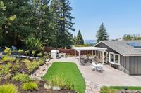 034 - 3165 Lucas Drive - Covered patio with outdoor kitchen, dining area, and landscaped yard with artificial turf.