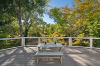 014 - 973 4th Street - Outdoor deck with a picnic table overlooking lush green trees.