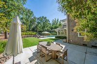 041 - 111 - 2116 Stewart Avenue - Backyard patio with outdoor dining set, green lawn, and a pool surrounded by trees