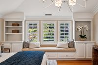 26 - 231 Sundown Terrace - ozy bedroom nook with a built-in window seat, white shutters, and surrounding cabinetry with shelving
