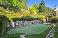 39 - 231 Sundown Terrace - Backyard putting green and flower beds on a landscaped slope and staircase leading to the house.