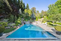 52.5 - 231 Sundown Terrace - Backyard pool surrounded by stone decking and lush landscaped gardens.