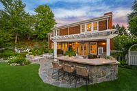 57 - 231 Sundown Terrace - Twilight view of the Stone patio with outdoor bar, seating area, and landscaped backyard