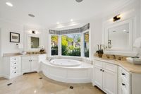 32 _ 910 Carl Road _ Spa-like primary bathroom with dual vanities, soaking tub, and abundant natural light from a large bay window.