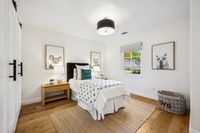 37 _ 910 Carl Road _ Bright bedroom with wide plank floors, modern lighting, and a cozy, airy layout.