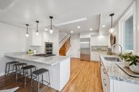 9 _ 849 Sibert Court _ Modern kitchen with large island bench, white cabinetry, pendant lighting, and timber flooring