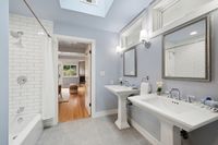 15 _ 849 Sibert Court _ Bathroom with double pedestal sinks, bathtub with shower, and neutral tiled finishes