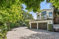 47 _ 1089 Rahara  Drive _ Driveway with garage, balcony, and surrounding trees