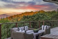 41 _ 665 Sky Hy Circle _ Outdoor seating area on elevated deck with cable railing and hillside views at sunset sky backdrop