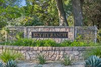 37 _ 665 Sky Hy Circle _ Stone entrance sign with landscaped greenery and mature trees at Sky Hy Ranch