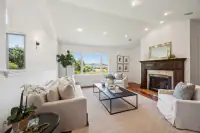 12 _ 21 Nemea Lane _ Living room with fireplace and large picture window overlooking trees and hills