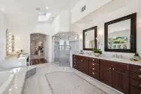 27 _ 21 Nemea Lane _ Primary bathroom with dual vanities, soaking tub, and glass-enclosed shower