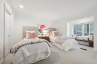 38 _ 21 Nemea Lane _ Bedroom with two beds and window seat overlooking the hillside grounds