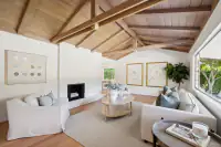 08 - 3435 Black Hawk Road - Living room with fireplace and exposed beam ceiling from opposite angle