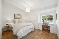 21 - 3435 Black Hawk Road - Guest bedroom with built-in desk, parquet hardwood floors, and garden-facing window