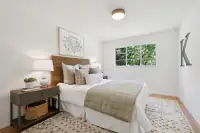 22 - 3435 Black Hawk Road - Guest bedroom with hardwood floors and large window overlooking the garden