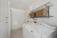 25 - 3435 Black Hawk Road - Laundry room with side-by-side washer and dryer, overhead storage, and built-in cabinetry