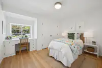 24 - 3435 Black Hawk Road - Guest bedroom with built-in desk, hardwood floors, and garden-facing window