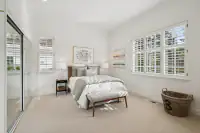 24 _ 2 Reliez Manor Court - Secondary bedroom with bed, nightstands, mirrored closet doors, windows, and bench seating