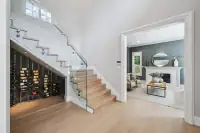 3 _ 31 Sandy Court _ Entry with staircase, built-in wine storage, and view into the living room