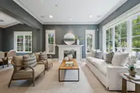 4 _ 31 Sandy Court _ Living room with fireplace, sofa, armchairs, and large windows