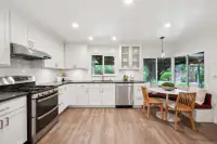8 _ 808 Rosedale - Kitchen with white cabinetry, stainless steel appliances, dark countertops, and a breakfast nook overlooking the backyard