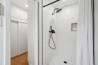 19 _ 808 Rosedale - Bright walk-in shower with white tile, a built-in niche, and black fixtures