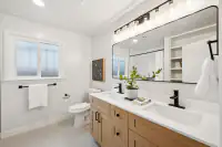 21 _ 808 Rosedale - Bright secondary bathroom with a double vanity, large mirror, and walk-in shower