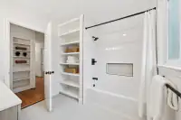 22 _ 808 Rosedale - Bright secondary bathroom with a tub-shower combo, built-in shelving, and white tilework