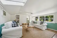 47 _ 1751 Reliez Valley Road _ Living area with large windows, two seating sofas, woven rug, and coffee table