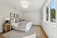 23 _ 3208 Camino Colorados _ Bedroom with a bed, side table, and large windows
