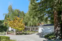 1 _ 4022 Happy Valley Road _ Front view with a driveway, landscaped yard, and large trees