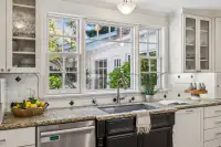 14 _ 4022 Happy Valley Road _ Kitchen sink with windows and glass-front cabinets
