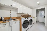 26 _ 4022 Happy Valley Road _ Laundry Room with washer, dryer, sink, and storage cabinets