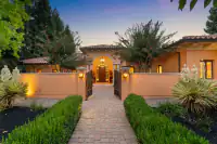 6 _ 24 Cosso Court _ Front entrance with brick walkway, open gates, and landscaped hedges