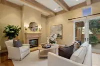 8 _ 24 Cosso Court _ Living room with fireplace, exposed ceiling beams, and seating area