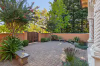10 _ 24 Cosso Court _ Front courtyard with brick pavers, wooden gate, and landscaped garden